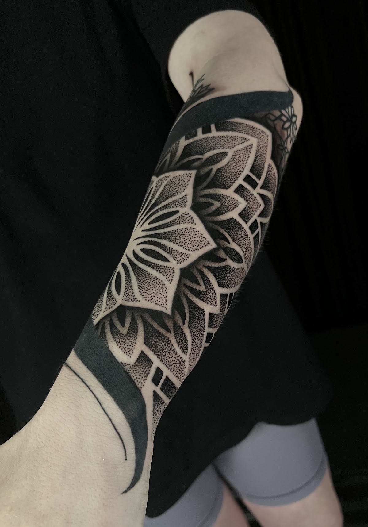 Intricate black dotwork mandala forearm sleeve tattoo